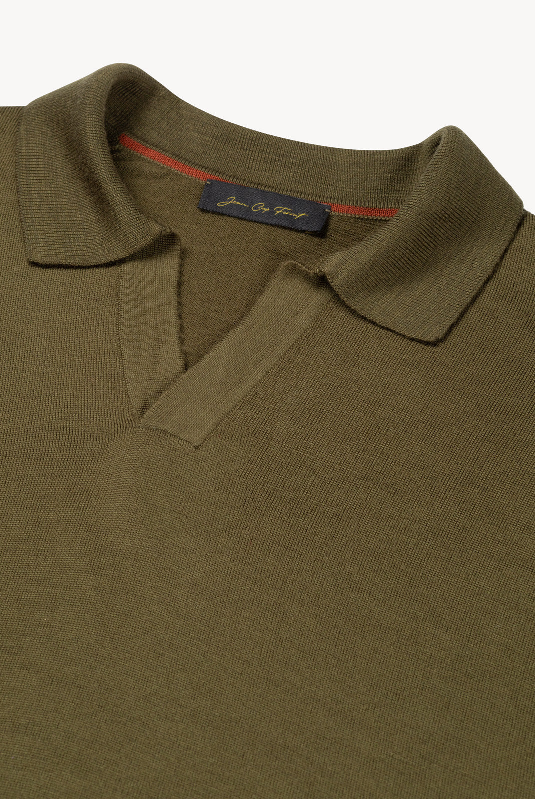 Detail of The Observer long-sleeve knitted polo in extra-fine merino wool, showing the buttonless open collar in Dark Olive
