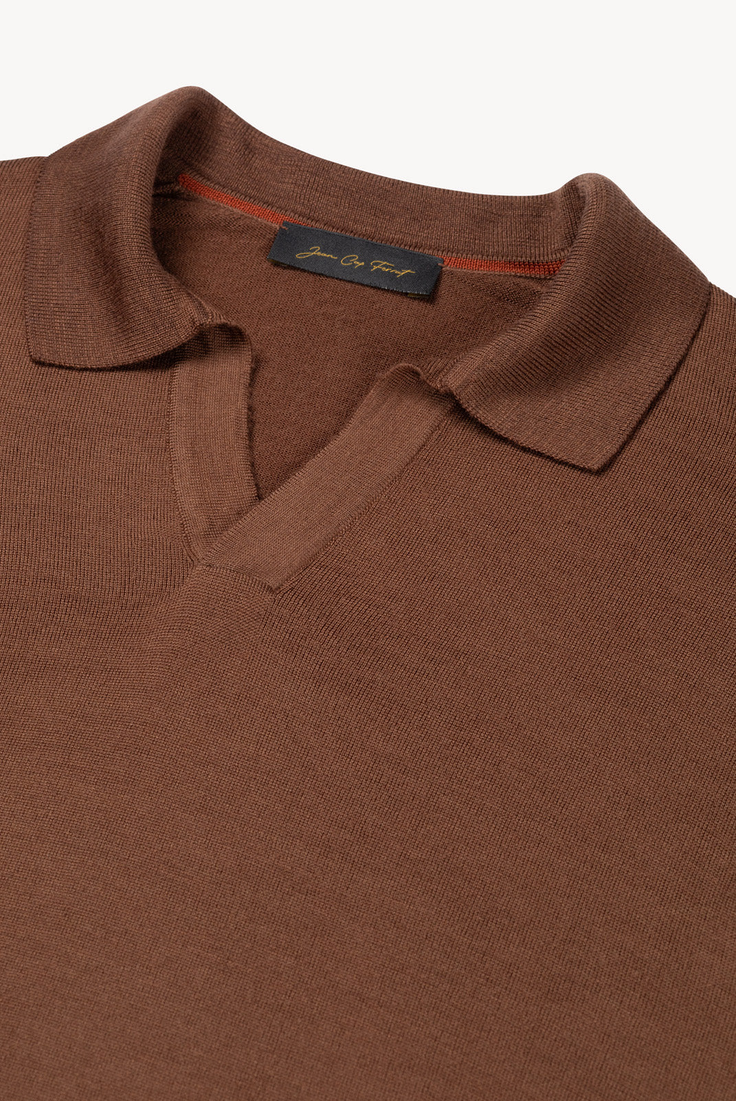 Detail of The Observer long-sleeve knitted polo in extra-fine merino wool, showing the buttonless open collar in Umber Brown
