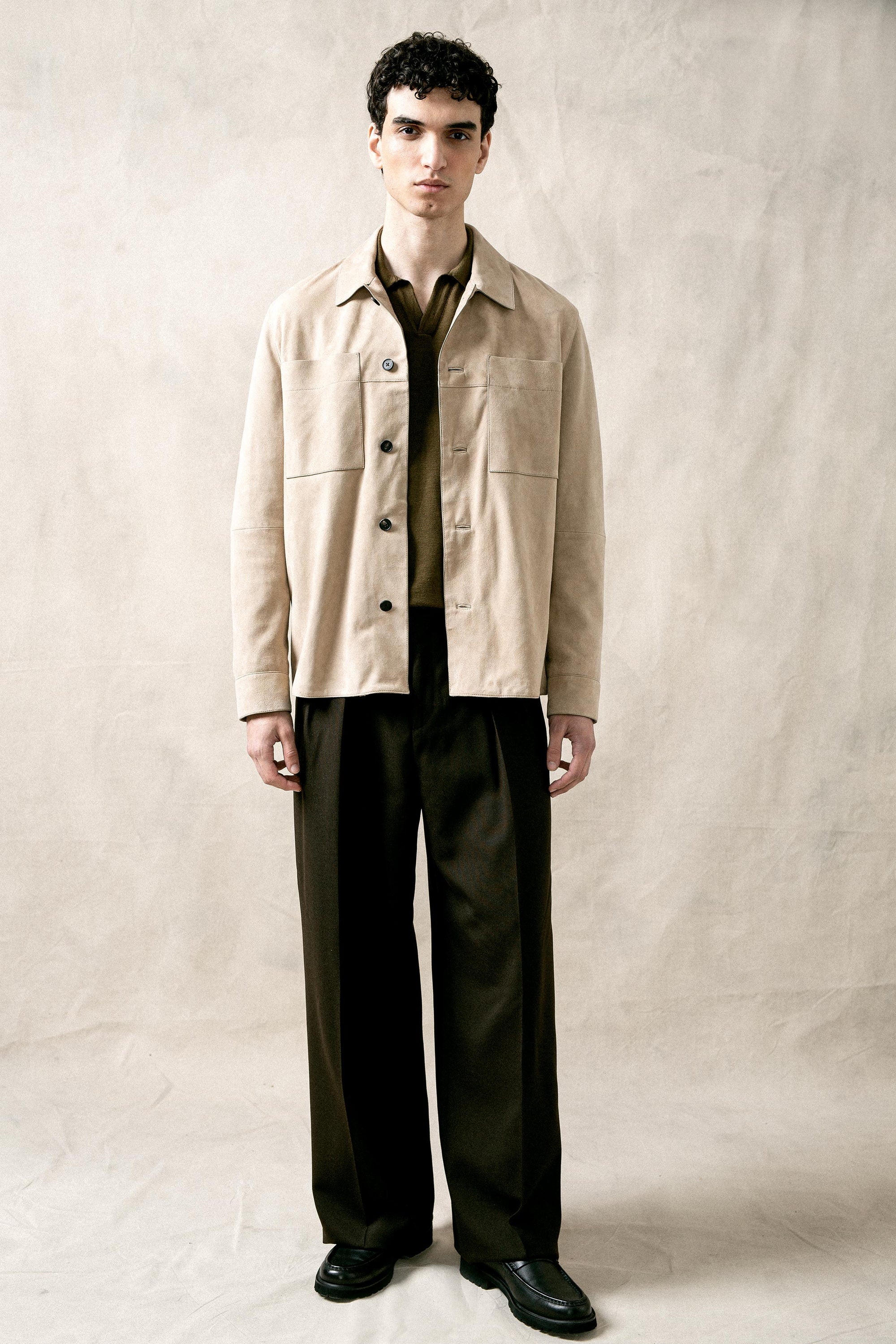 The Observer long-sleeve knitted polo in extra-fine merino wool, shown in Dark Olive, full body styled look on model
