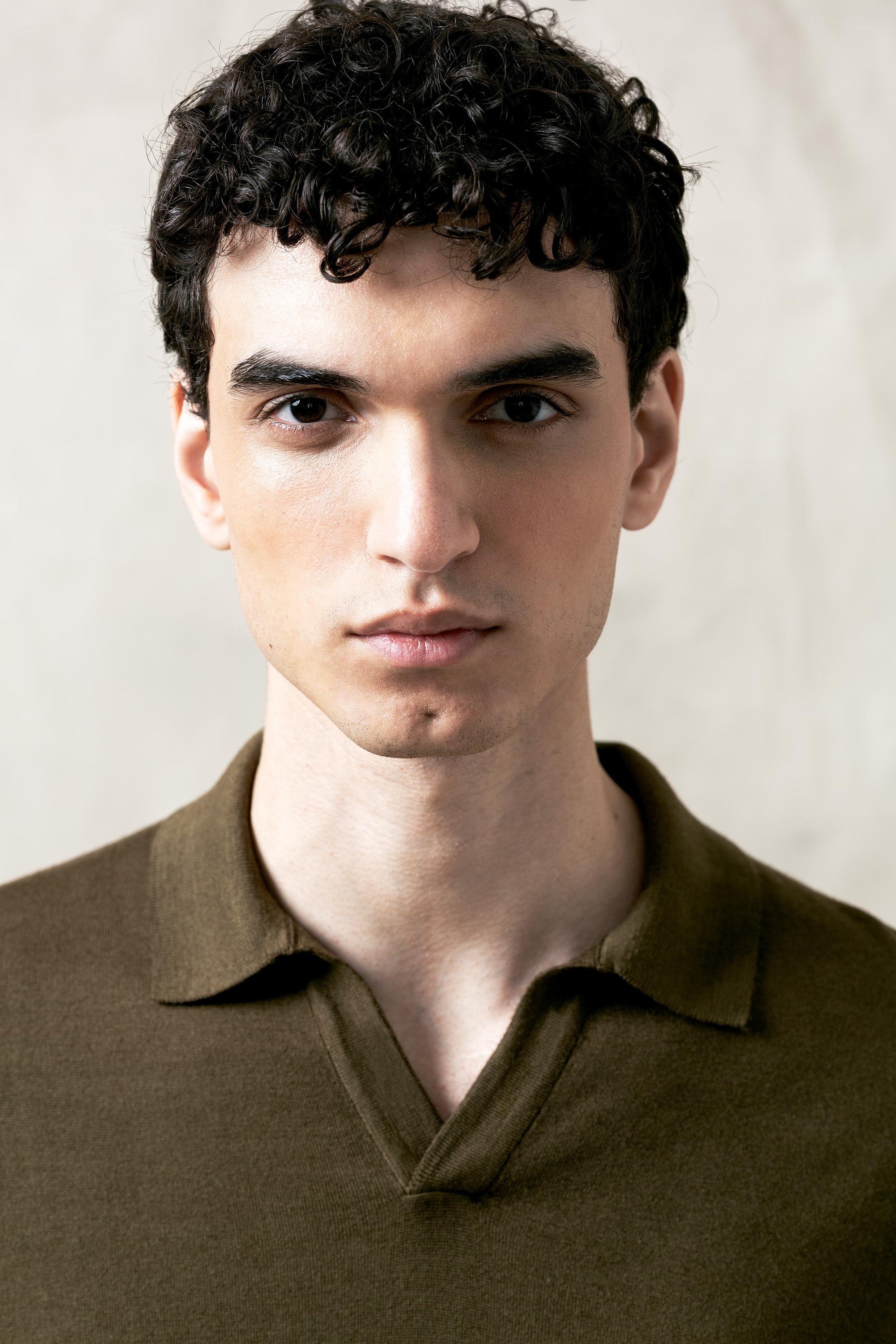 The Observer long-sleeve knitted polo in extra-fine merino wool, shown in Dark Olive, upper body view on model
