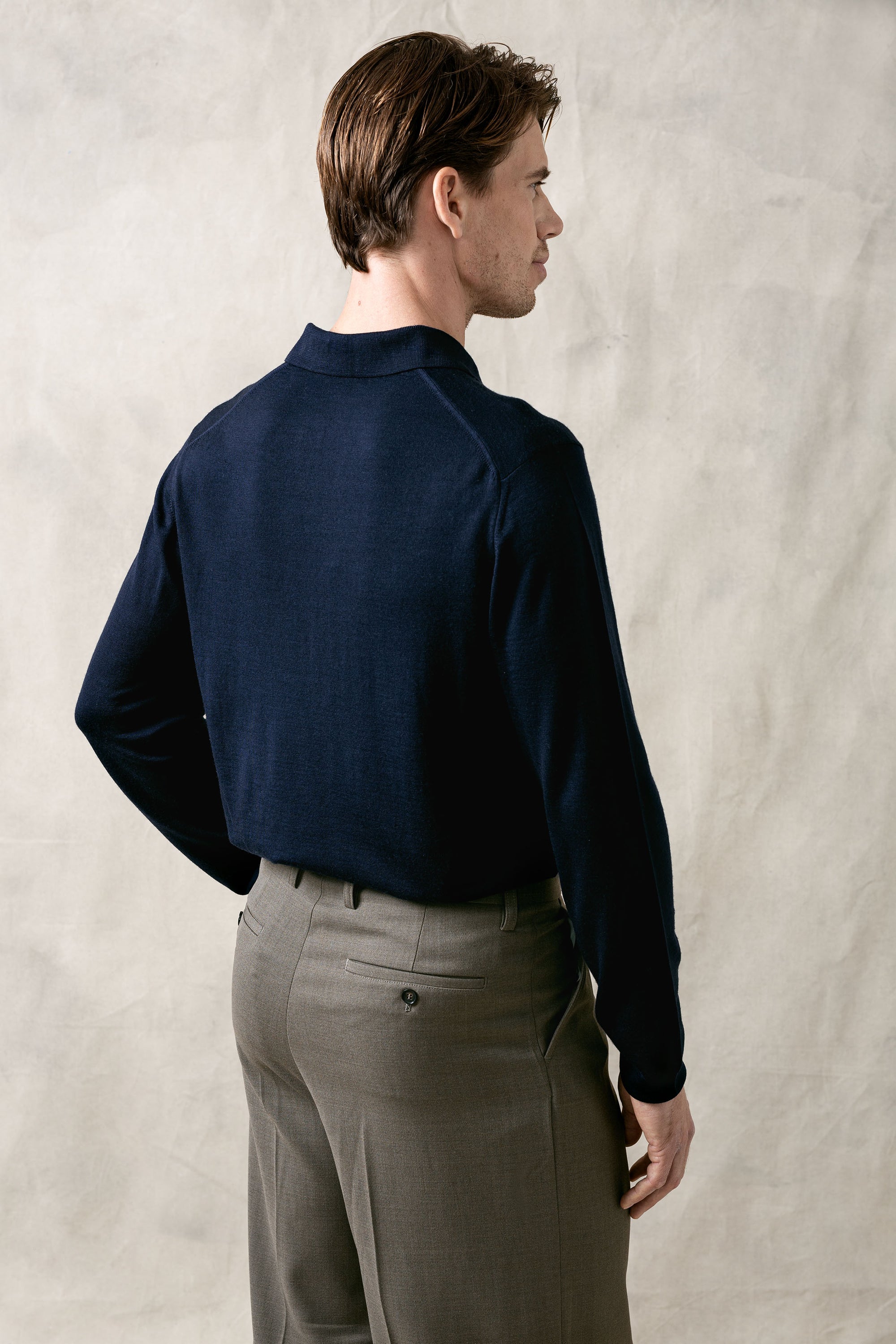 The Observer long-sleeve knitted polo in extra-fine merino wool, shown in Ink Navy back view on model.
