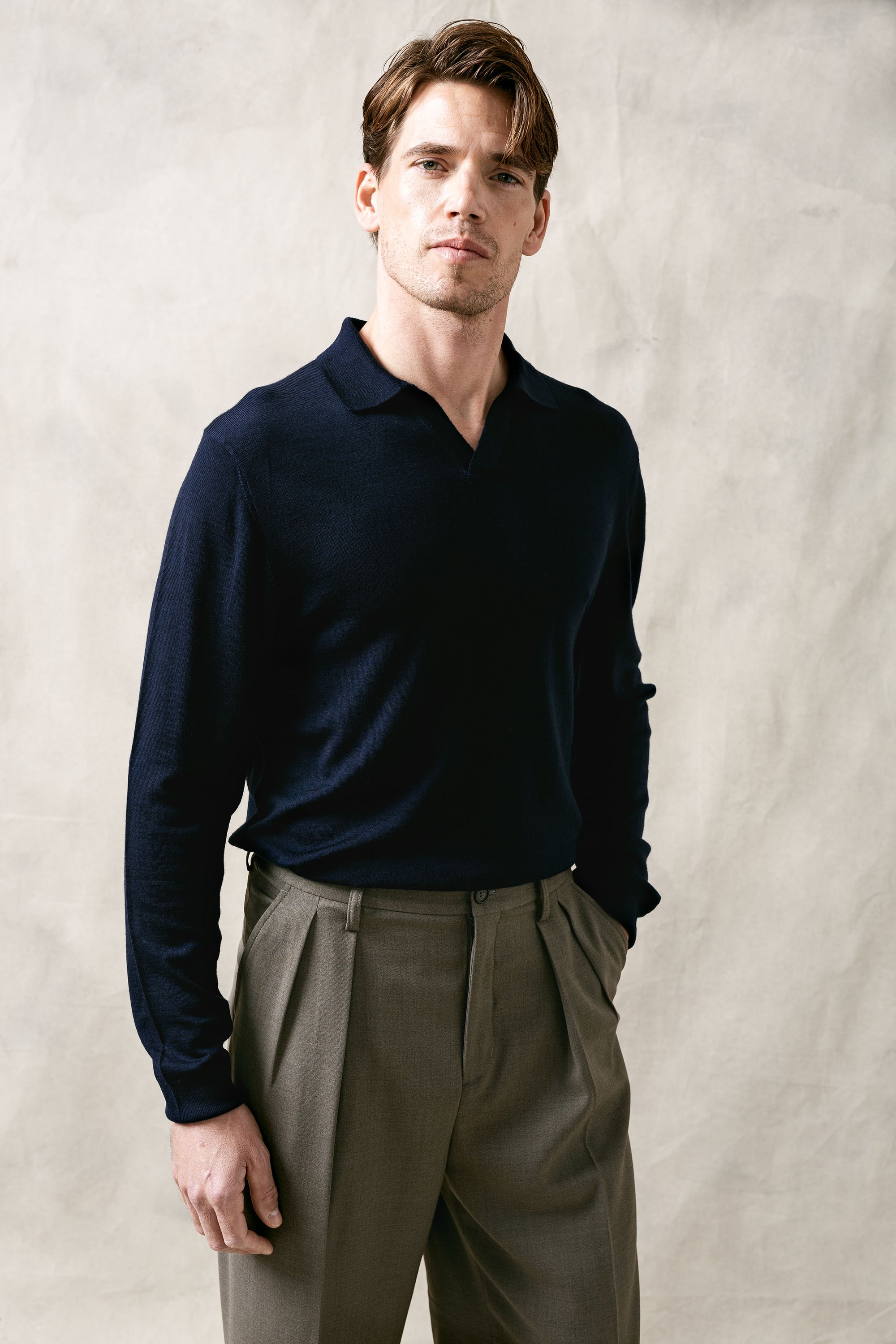 The Observer long-sleeve knitted polo in extra-fine merino wool, shown in Ink Navy, front view on model.
