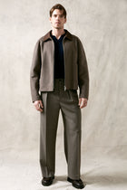 The Observer long-sleeve knitted polo in extra-fine merino wool, shown in Ink Navy, full body styled look on model.
