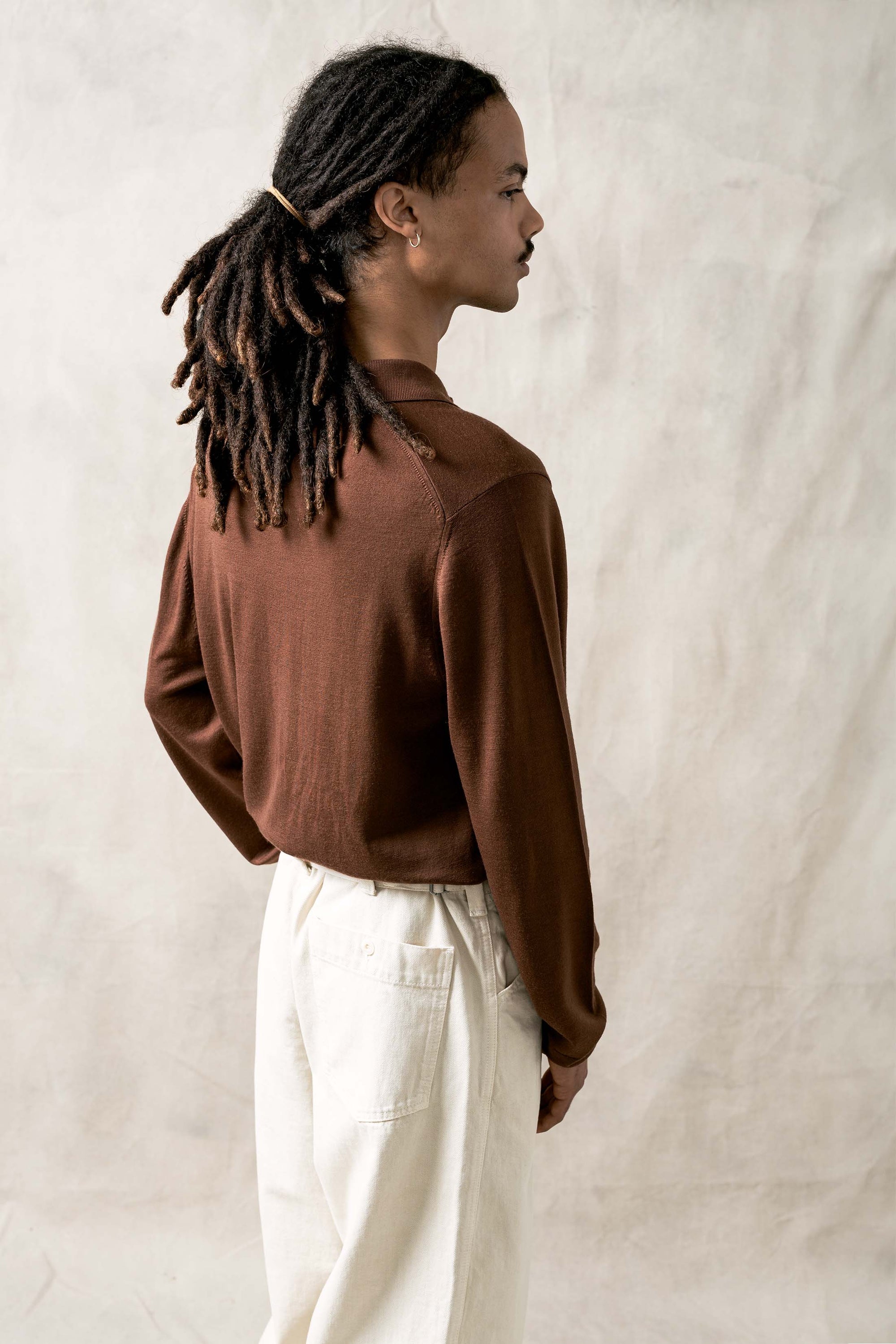 The Observer long-sleeve knitted polo in extra-fine merino wool, shown in Umber Brown, back view on model
