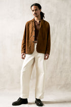 The Observer long-sleeve knitted polo in extra-fine merino wool, shown in Umber Brown, full body styled look on model
